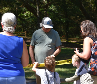 Archeologist shows visitors an artifact found at the site