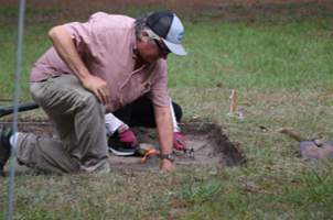 Archeologists work in an excavation pit