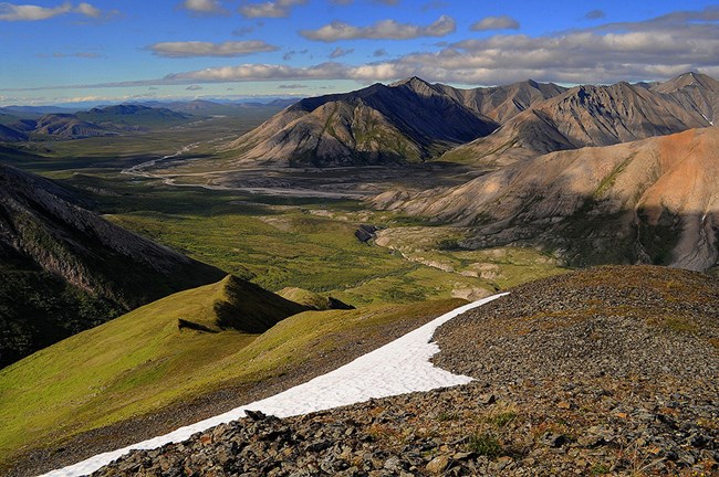 Looking down from a mountain across a mountain range and river valley.