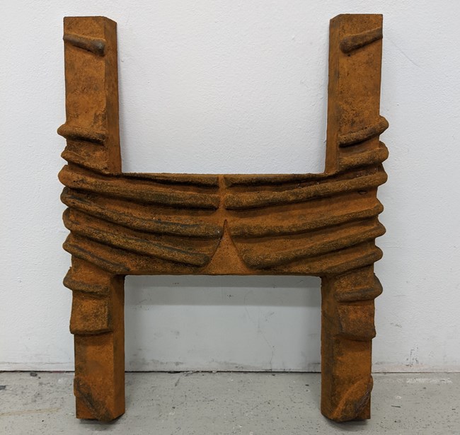 An oversized cast iron mold weight in the shape of the letter H A cast iron mold weight in the shape of the letter H