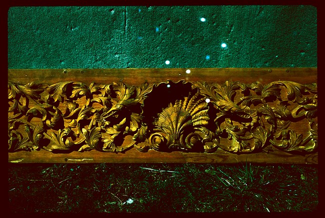 Cockleshell Decorative wood cockleshell with intricate leaf patterns surrounding it.