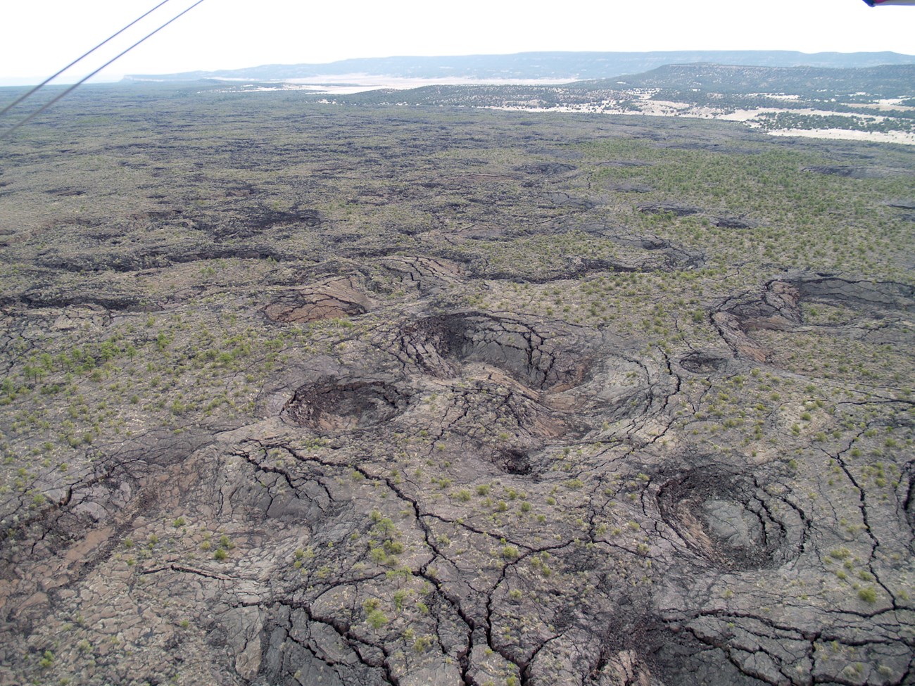 Inf_Pits_McCartys_2 photo of rocky land surface with cracks and rounded pits