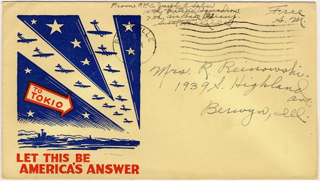 Envelope with an illustration showing a V-shaped formation of airplanes flying towards a target. Target is identified by an arrow, “To Tokio.” Image is in blue; text is in red.