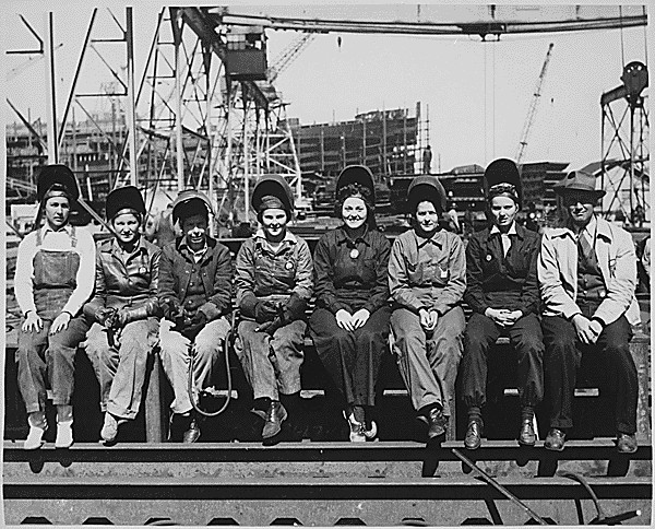 Ingalls Shipbuilding Corps. Courtesy of the National Archives Black and white photo of eight white women in coveralls and weling helmets