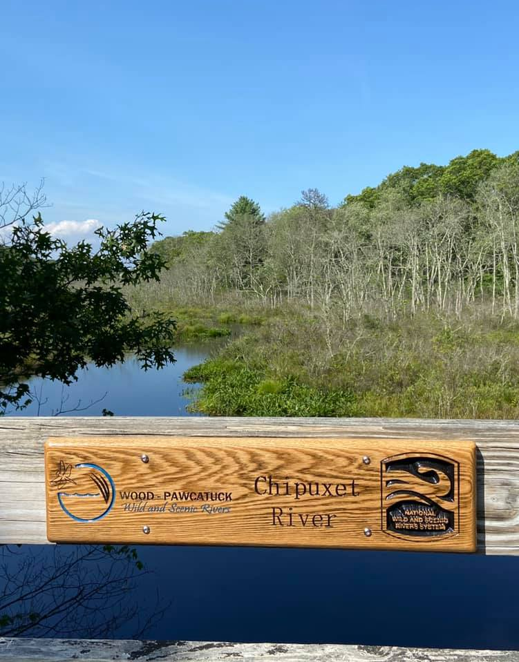 River crossing sign installed along a bike path over the Chipuxet River, South Kingstown, RI to instill pride in the achievement of Wild and Scenic designation. Photo by Bill McCusker. River crossing sign installed along a bike path over the Chipuxet River, South Kingstown, RI to instill pride in the achievement of Wild and Scenic designation. Photo by Bill McCusker.
