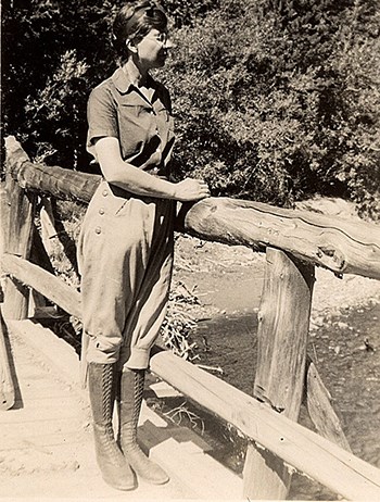 Isabel Bassett Wasson wearing breeches and knee boots while standing on bridge