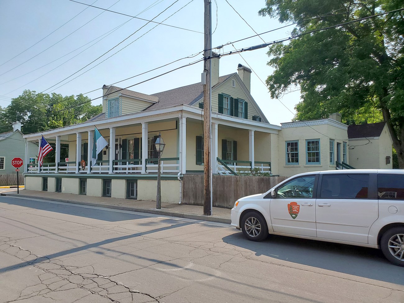 Yellow and white historic wooden building with a masonry foundation.