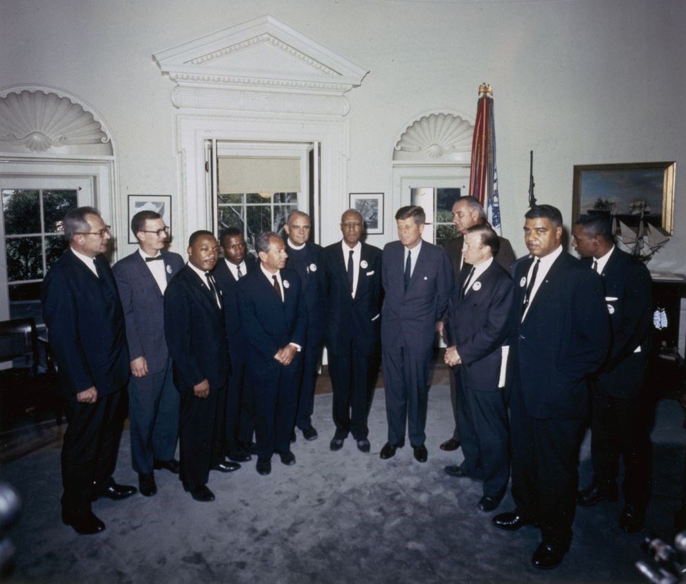 President Kennedy stands in a semi-circle with organizers of the March on Washington in the Oval Office.
