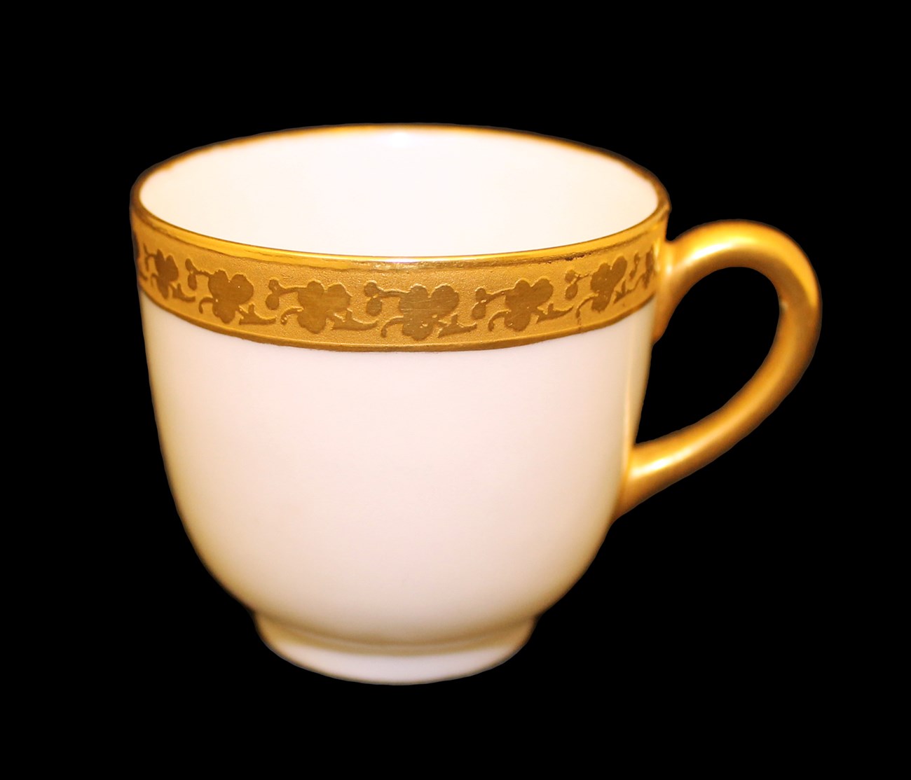 lt= White china cup with gold handle and gold rim decorated with shamrocks