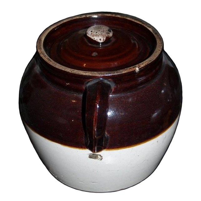 a brown and white pot used for cooking beans