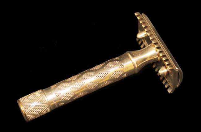 Silver safety razor with straight handle and single blade