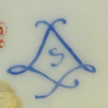 Blue mark on white ceramic of S enclosed in two cursive Ls