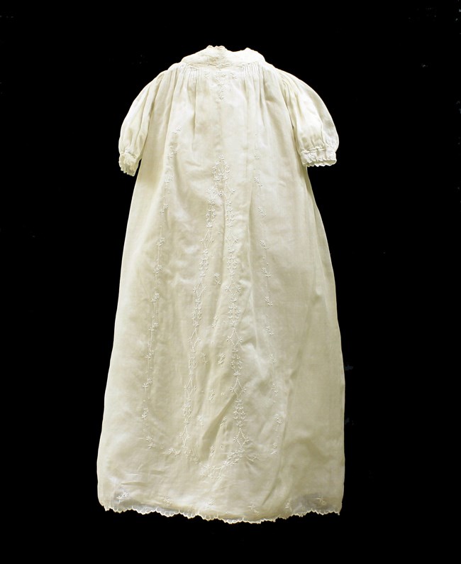 Long off-white baby's christening gown with lace decoration