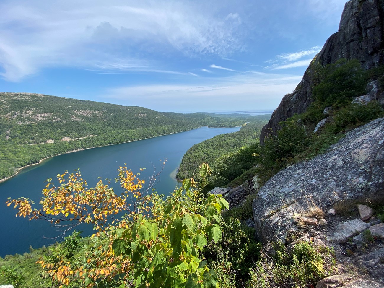 View of a pond and landscape from a trail along a cliff