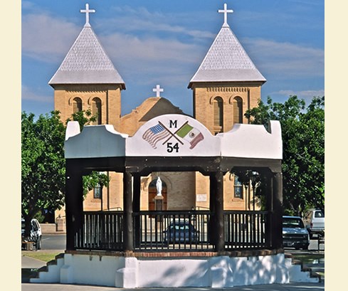 The view from the south end of Mesilla Plaza includes a central bandstand in the foreground and the 1906 Basilica of San Albino, which occupies the same site on the plaza as an earlier adobe church built in 1857. Photo © Jack Parsons