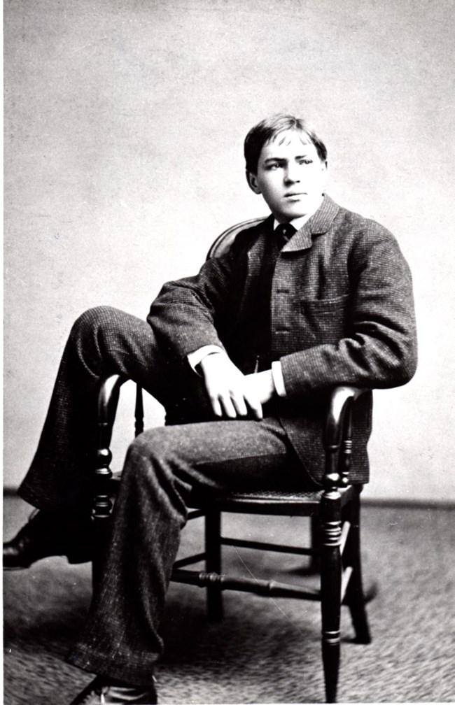 JRG AsTeen.2 A teenage bou sitting in a chair with his left hanging over the arm