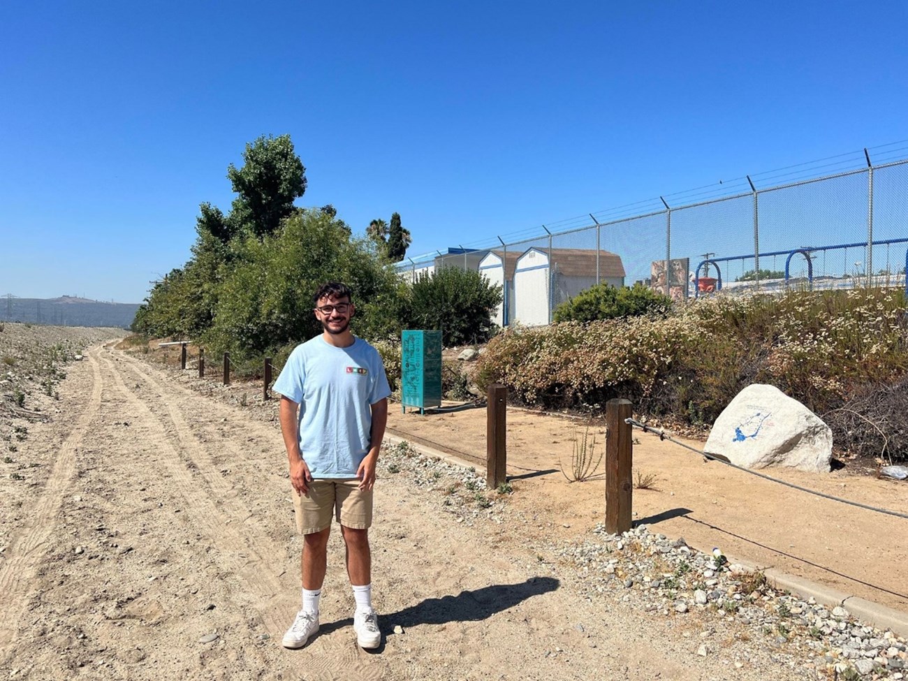 Diego Borgsdorf, the Cultural Geography and GIS intern at the Juan Bautista de Anza National Historic Trail, stands on the Amigos de Los Rios site of La Primaria along the San Gabriel River Trail.