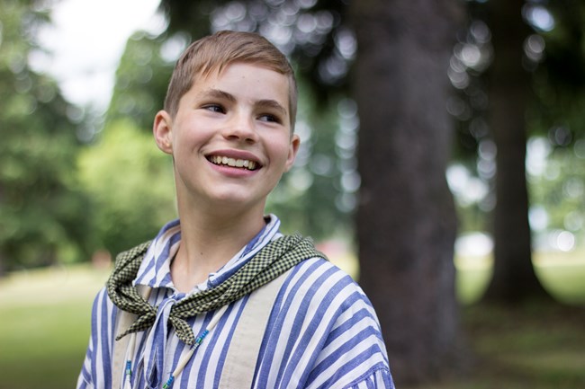 A boy wearing a blue and white striped shirt.