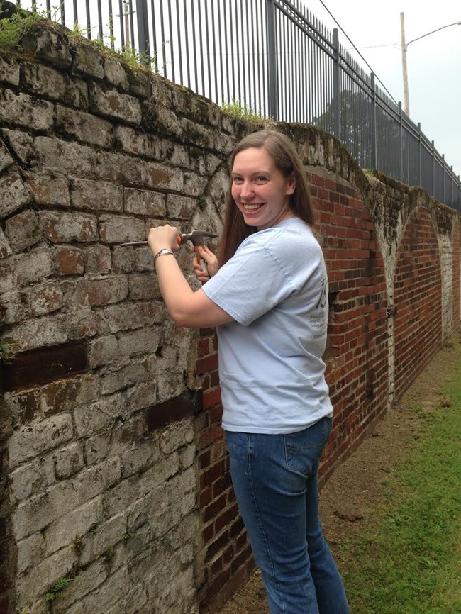 Jamie Dail (MFA, Historic Preservation 2015) removes failed mortar from a historic brick wall. Jamie Dail (MFA, Historic Preservation 2015) removes failed mortar from a historic brick wall.