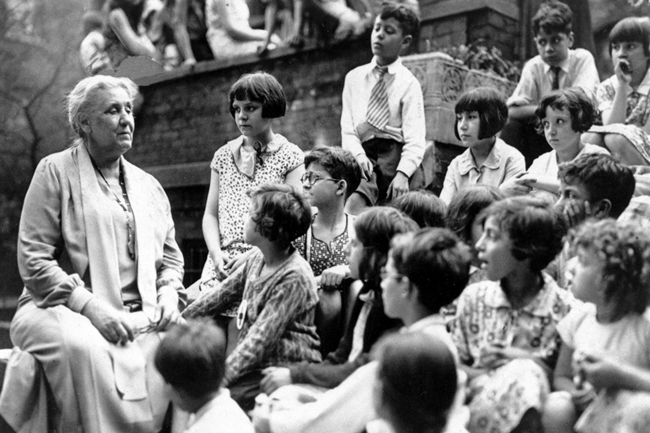 Jane Addams sitting with children at the Hull House.