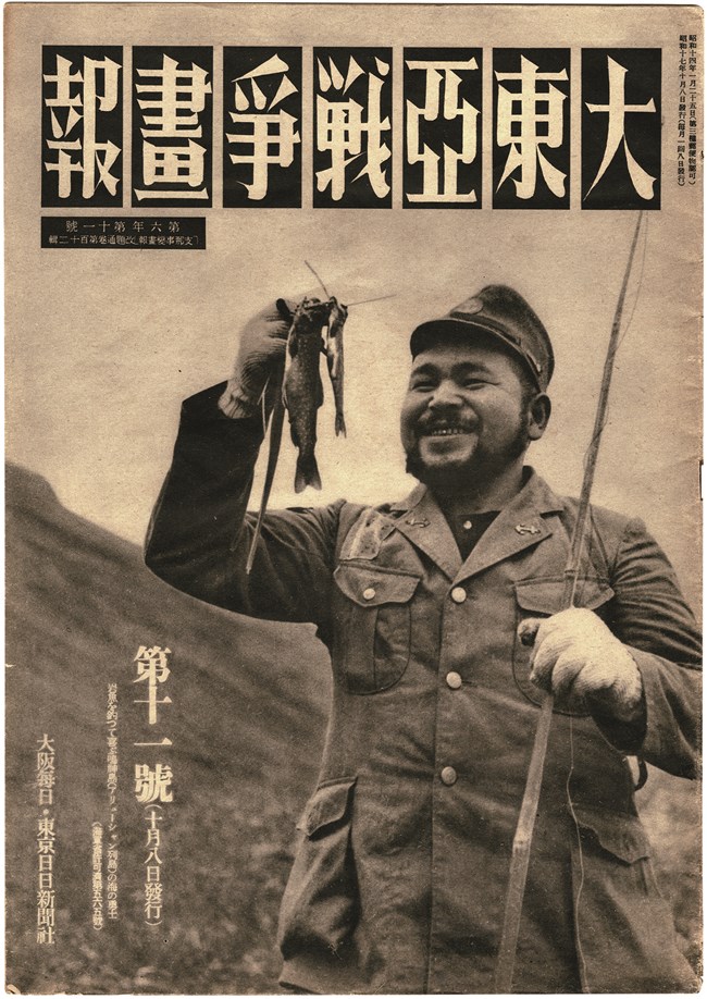 magazine cover with Japanese writing, that depicts a Japanese soldier holding a fish and smiling.