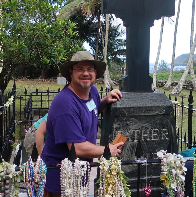 Jason Church at KALA cleaning the grave of Father Damien