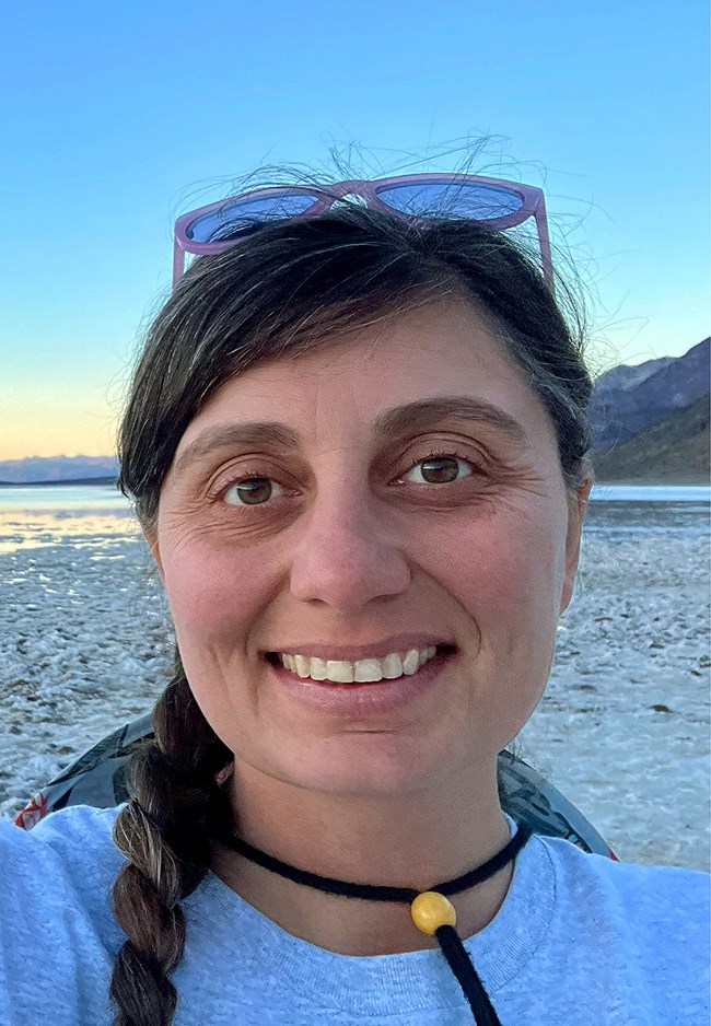 A smiling person selfie with a vast desert background.