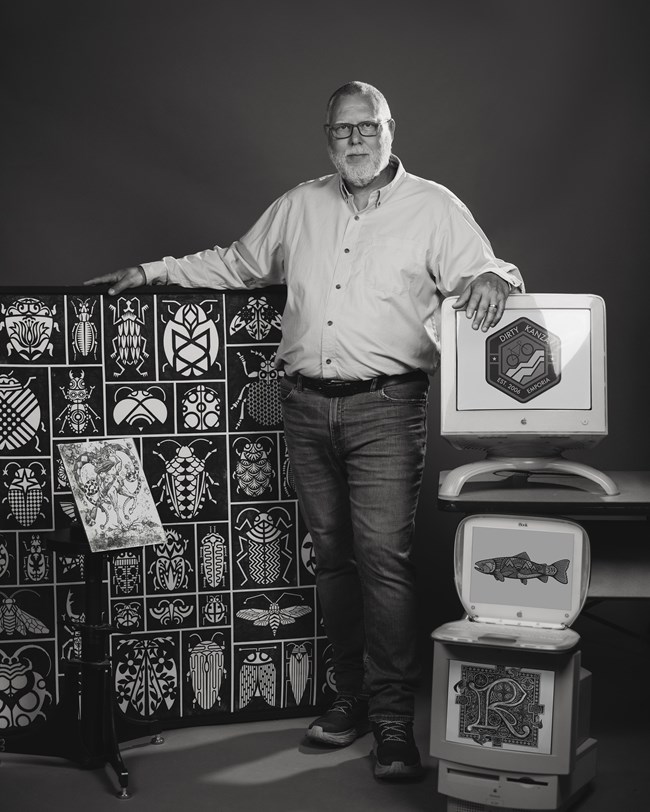 Black and white image of a man standing with original artwork
