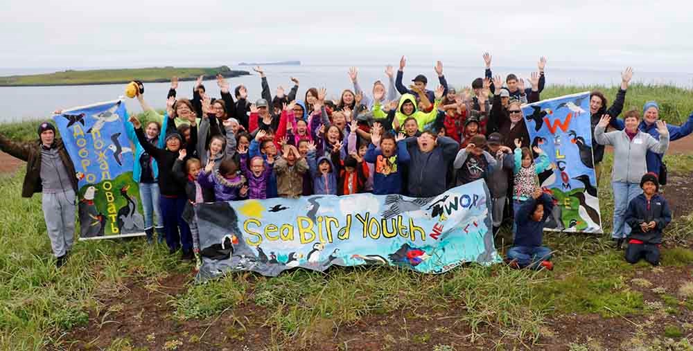 A group of kids with banners for the Seabird Youth Network
