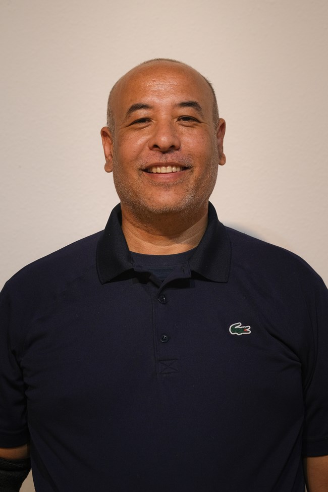 Portrait of a man smiling at the camera from the chest up.