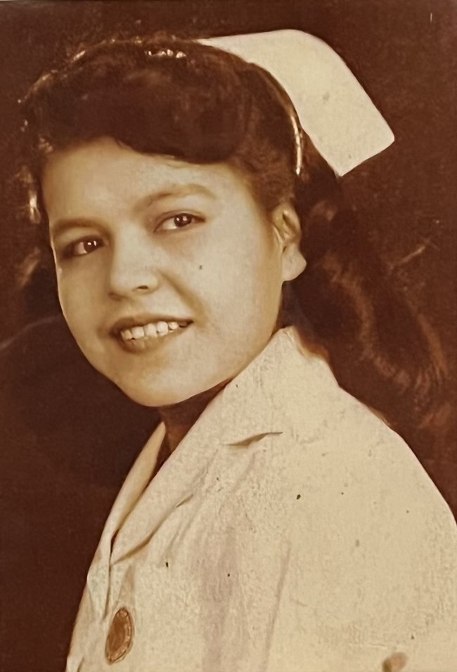 Sepia portrait of a young woman with glossy dark hair in a nursing uniform and cap.