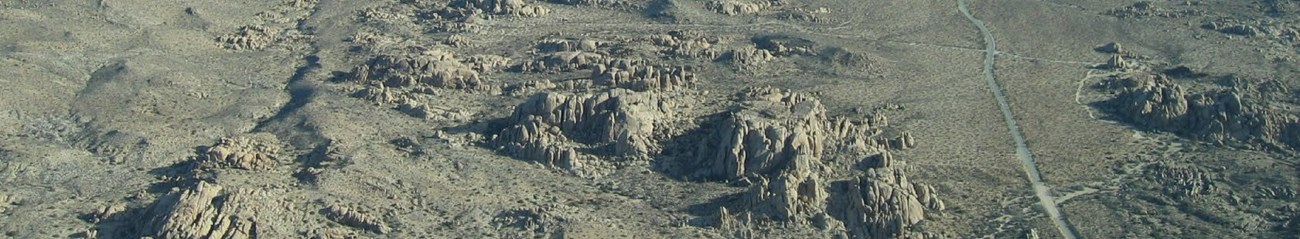 An aerial view of rocks and land of a campground and road.