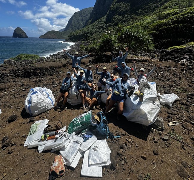 People posing with trash on beach.