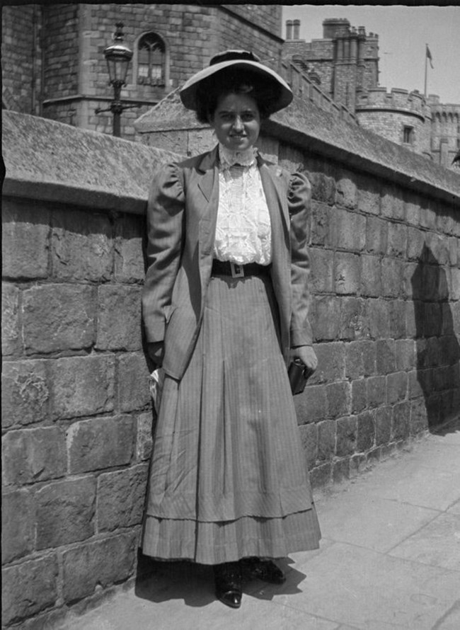 Rose Kennedy stands in front of a stone wall.