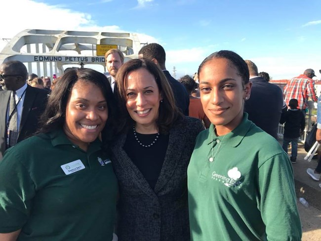 three women smiling for a picture with vice president kamala harris