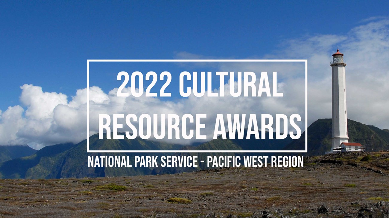 Tropical landscape with white lighthouse tower on right. In background, steep lush mountains capped with clouds. Reads “2022 Cultural Resource Awards. National Park Service. Pacific West Region.”