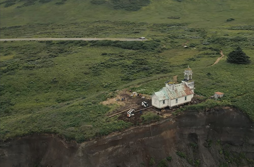 An historical church sits on an eroding cliff.