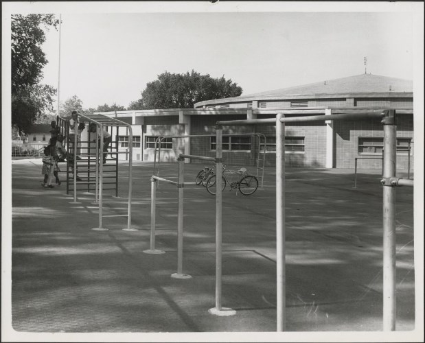 Katherine B. Richardson Elementary School playground, with three children on monkeybars, and two bicycles