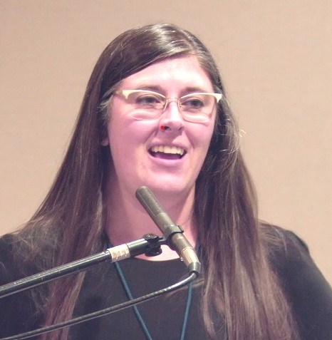 Katherine Boles, the presenter, speaking at a lectern.