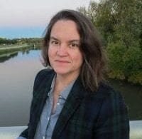 Photo of the speaker Kathryn Holliday with a river landscape in the background.