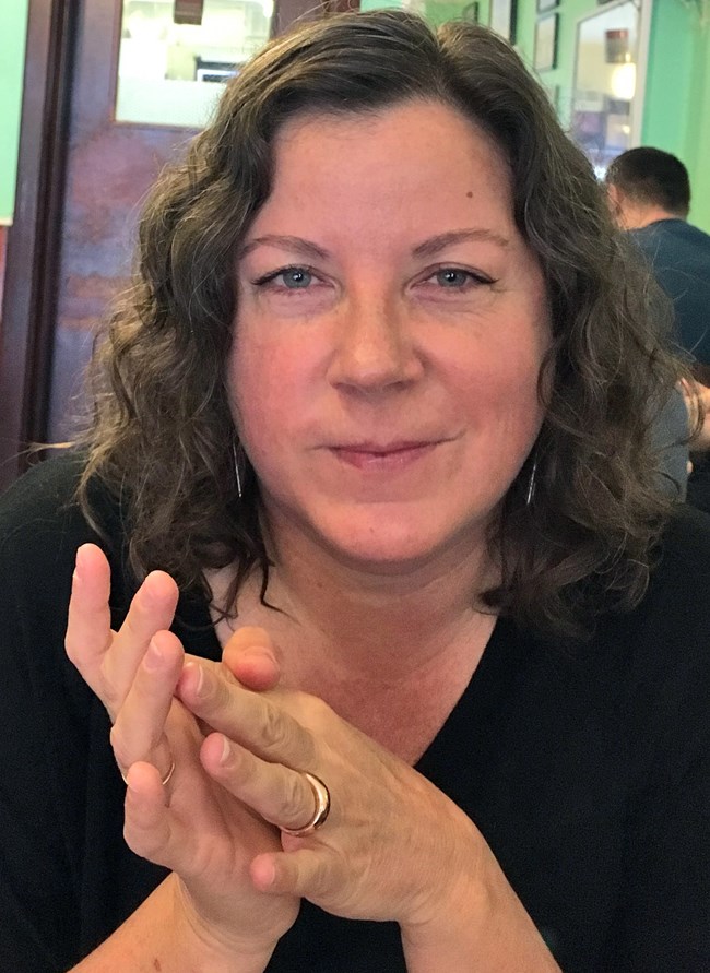 Portrait of Katy seated at a table.