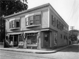 Black and white photo of a two story store and home.