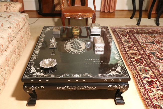 A color image showing a black coffee table with a Korean inscription