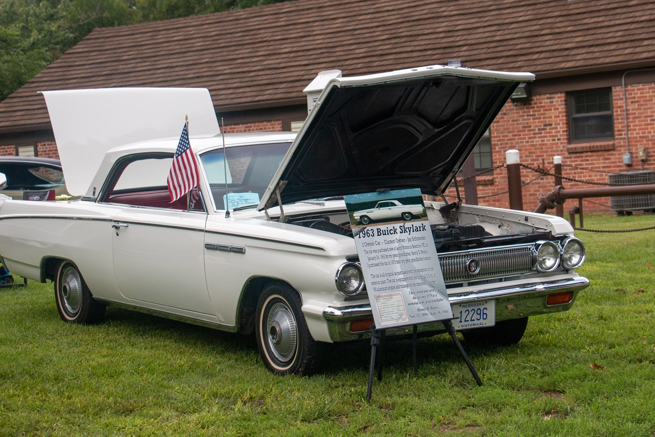 Korslund25September 01, 2019_MG_5488 A white antique Buick is parked with it's hood up.