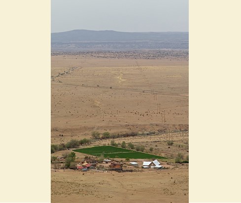 The awesome view looking south from La Bajada Mesa includes La Bajada village in the foreground and the far-reaching squiggles of old Camino Real pathways in the distance. Photo © Jack Parsons