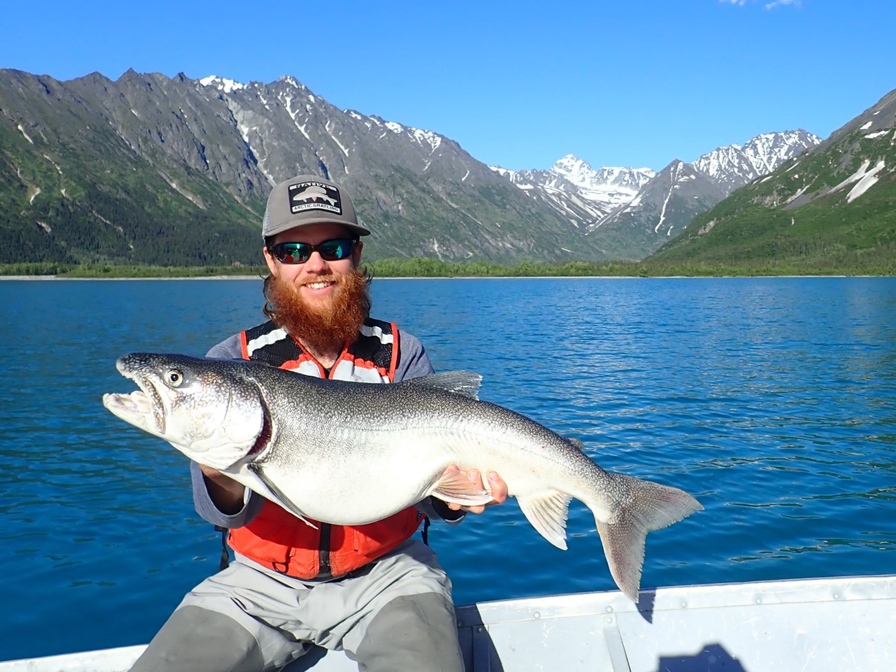 Angler with Lake Trout near lake.
