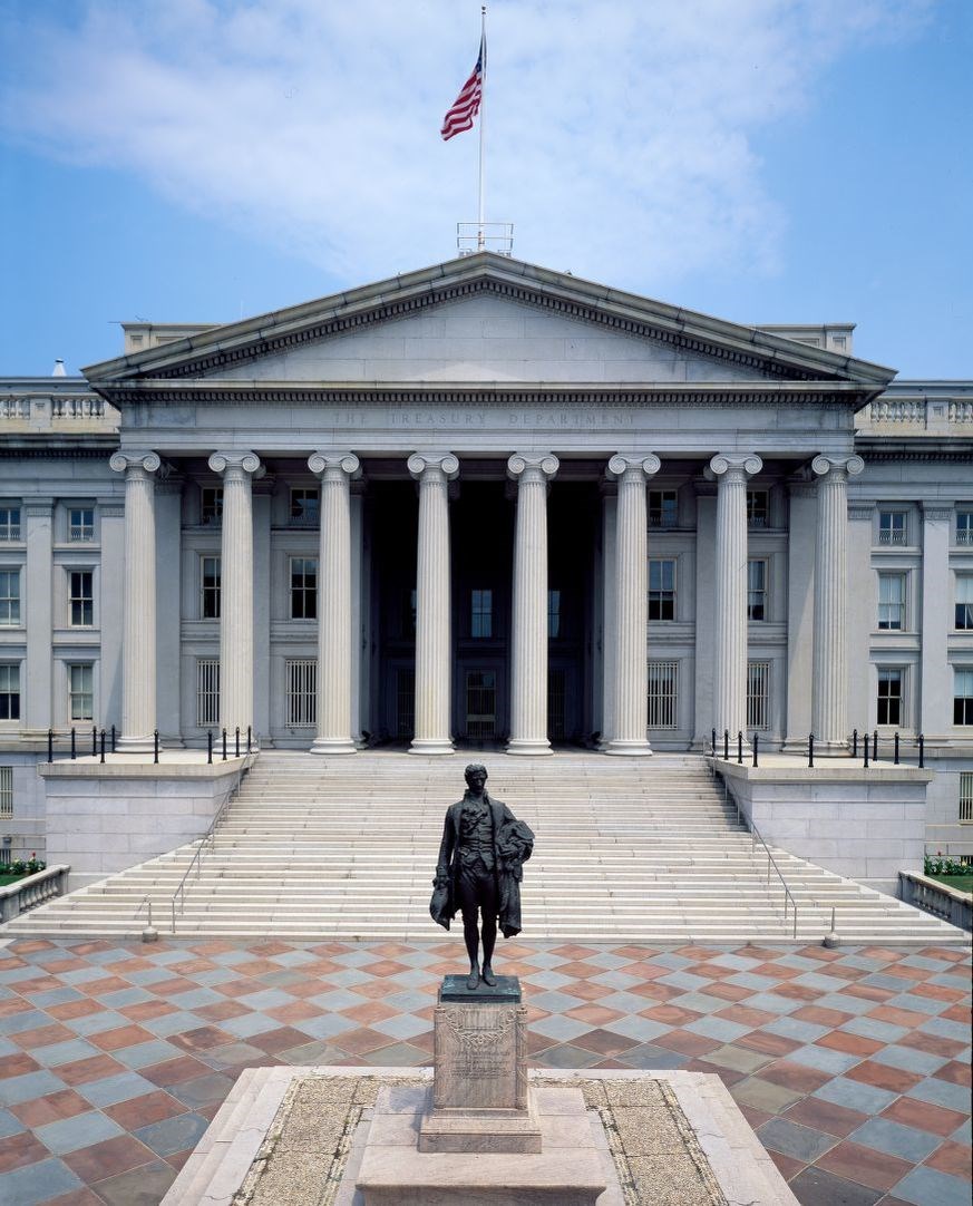 Statue of Alexander Hamilton on a pedestal in front of the Treasury building in Washington D.C.
