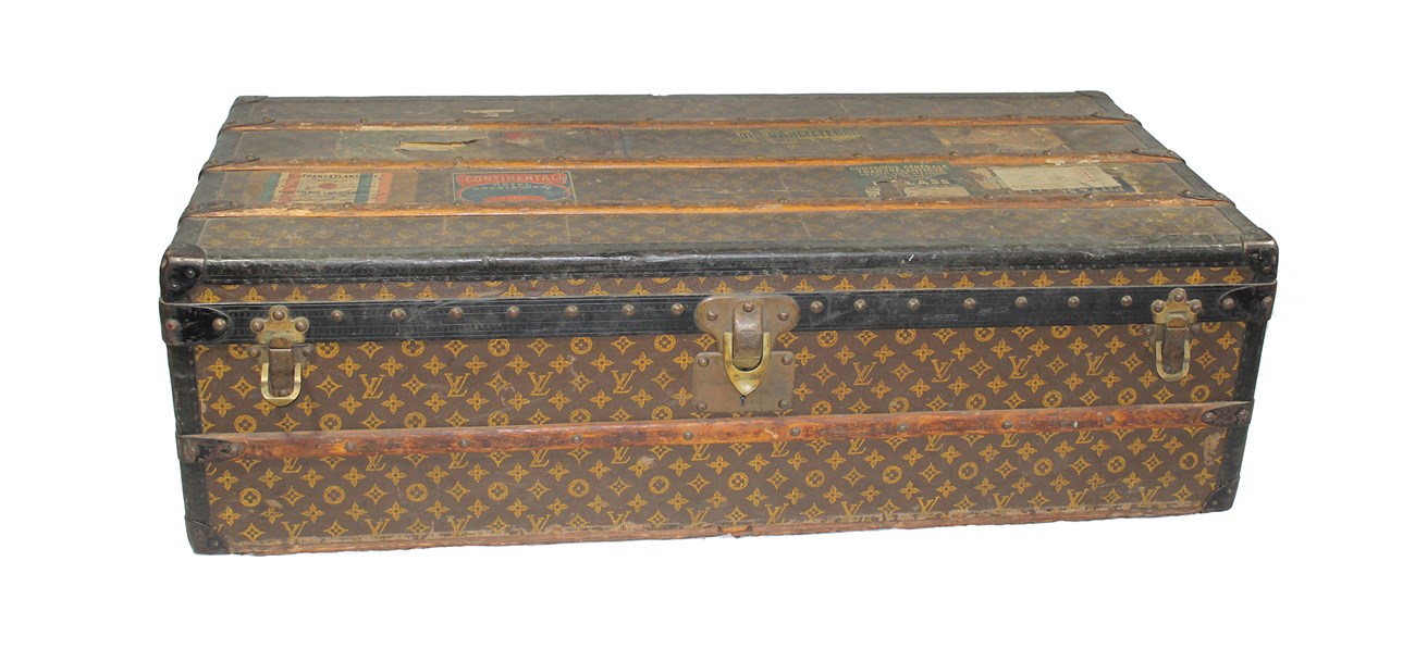 Rectangular top with flat lid, overall pattern of four-petal flowers and LV logo.