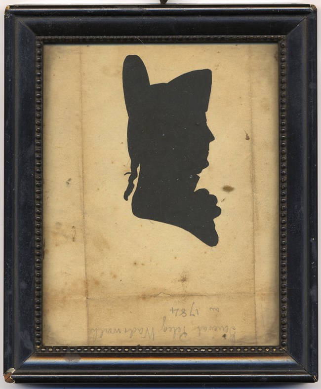 LONG 19681 Silhouette of man wearing tall military hat.