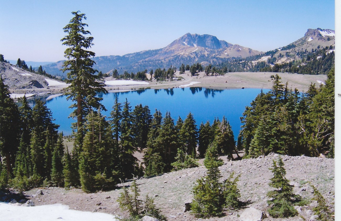 Lassen Volcanic Brokeoff Mountain and Lake Helen, NPS Photo A blue lake surrounded by trees in the foreground, a mountain the background